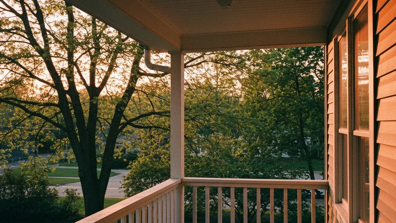 atmospheric photograph of summer light filtering through trees onto a porch, peaceful and quiet